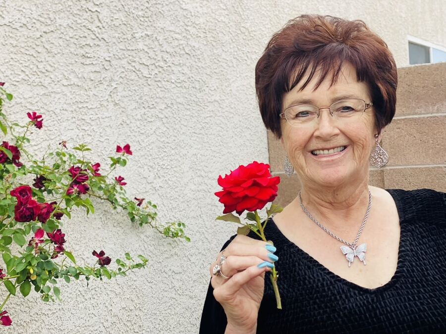 Marilyn F. Brady holding a red rose